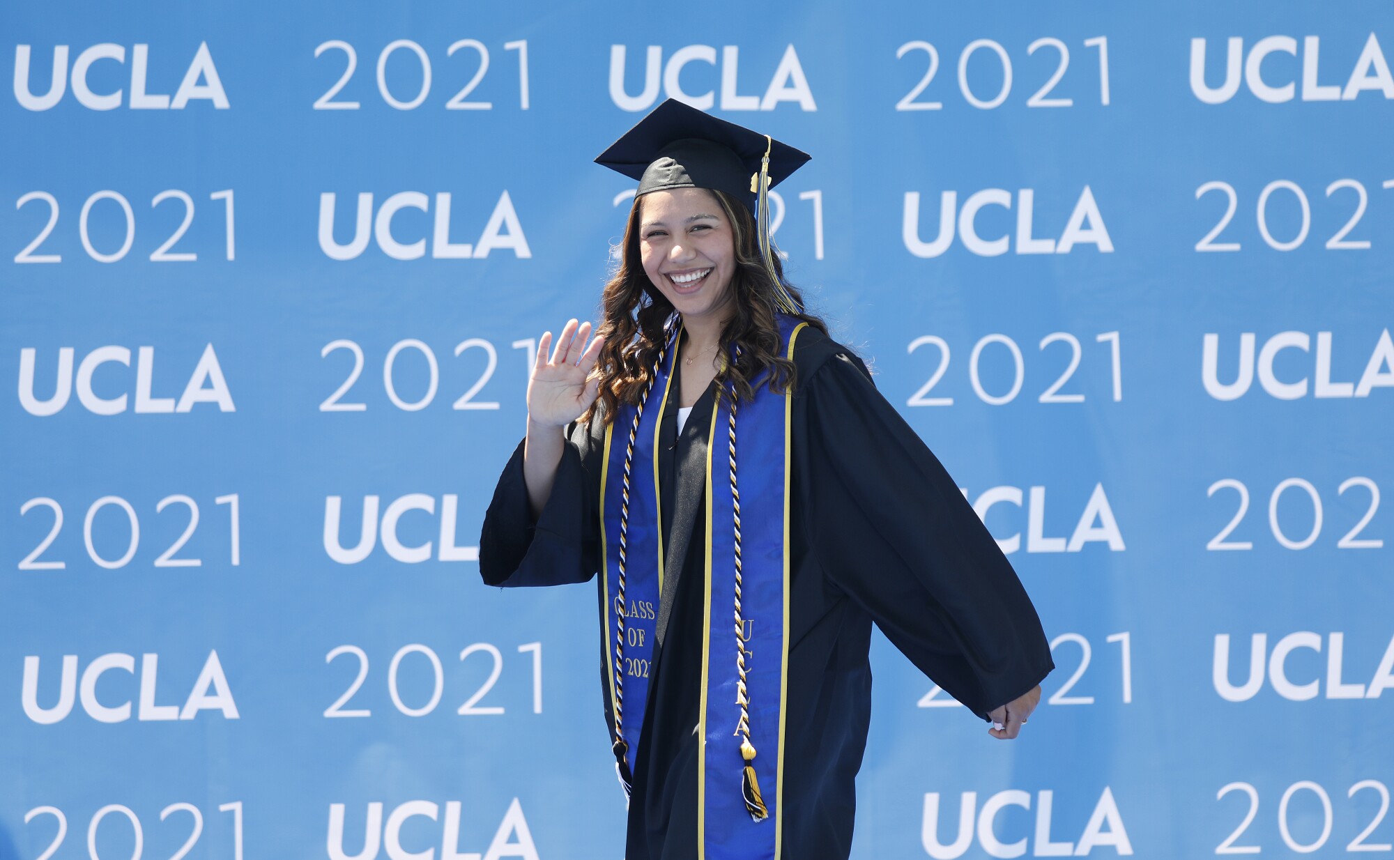 Graduating with a degree in biology and Chicana/o Studies, Jennifer Bribiesca waves to her family.