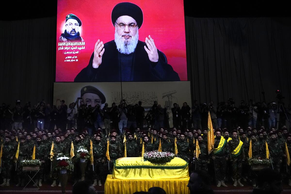 Hezbollah fighters stand behind the coffin of their top commander Fouad Shukur, who 