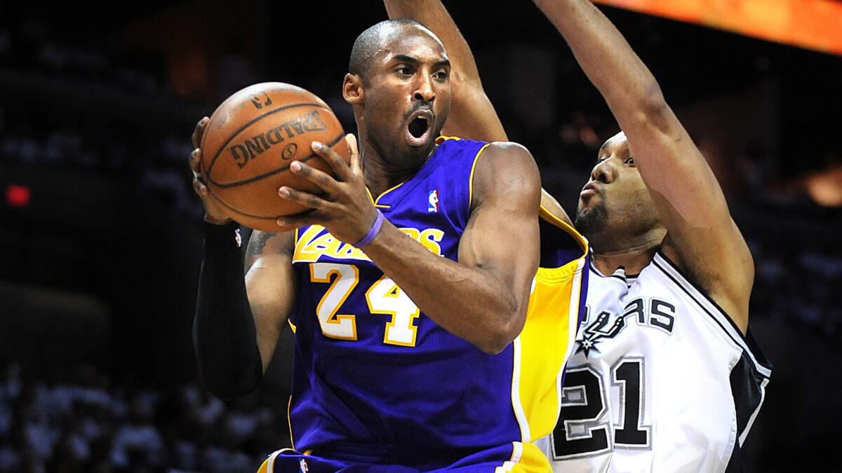Spurs forward Tim Duncan forces Lakers guard Kobe Bryant, left, to pass after driving to the basket during a playoff game in 2008.