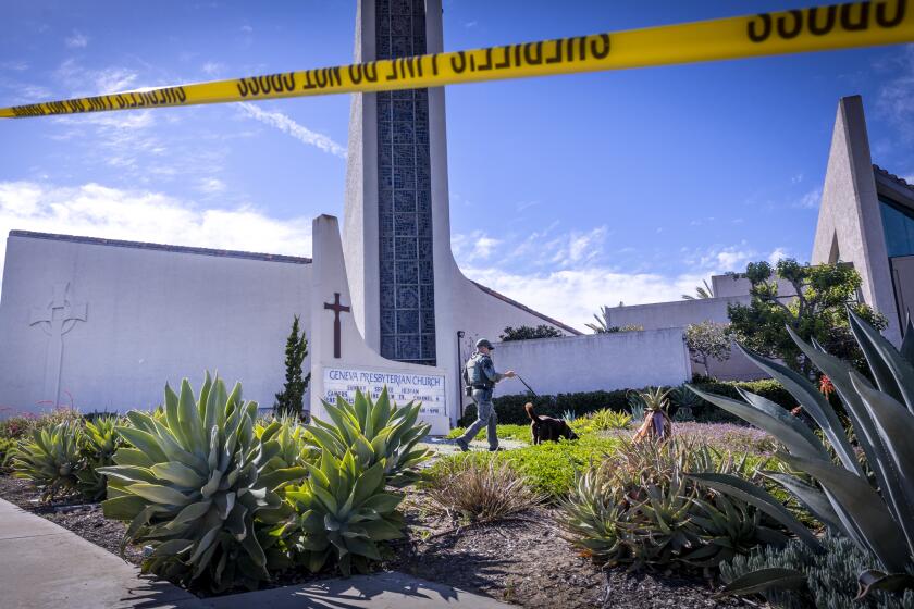 Laguna Woods, CA - May 15: An Orange County Sheriff's Officer with a bomb-sniffing dog checks the exterior of the church after a person opened fire during a church service attended by a Taiwanese congregation, killing one person and critically injuring four others at Geneva Presbyterian Church in Laguna Woods Sunday, May 15, 2022. Authorities are interviewing more than 30 people who were inside the church at the time. The victims were described as mostly Asian and mostly of Taiwanese descent, authorities said. A law enforcement source said officials believe the suspect was a 68-year-old Asian man who is originally from Las Vegas. The source said after the suspect opened fire he was "subdued" by parishioners. No other details were available. (Allen J. Schaben / Los Angeles Times)