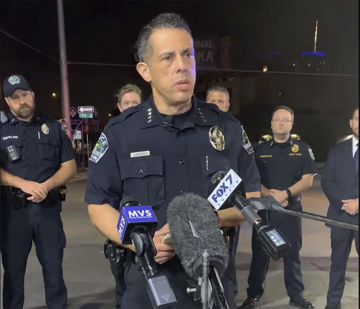 Police Chief Joseph Chacon speaks in front of microphones with several officers behind him