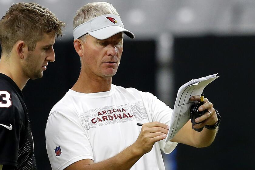 Arizona Cardinals offensive coordinator Mike McCoy, right, explains a play to rookie quarterback Josh Rosen (3) during NFL football practice Thursday, Aug. 9, 2018, in Glendale, Ariz. (AP Photo/Ross D. Franklin)