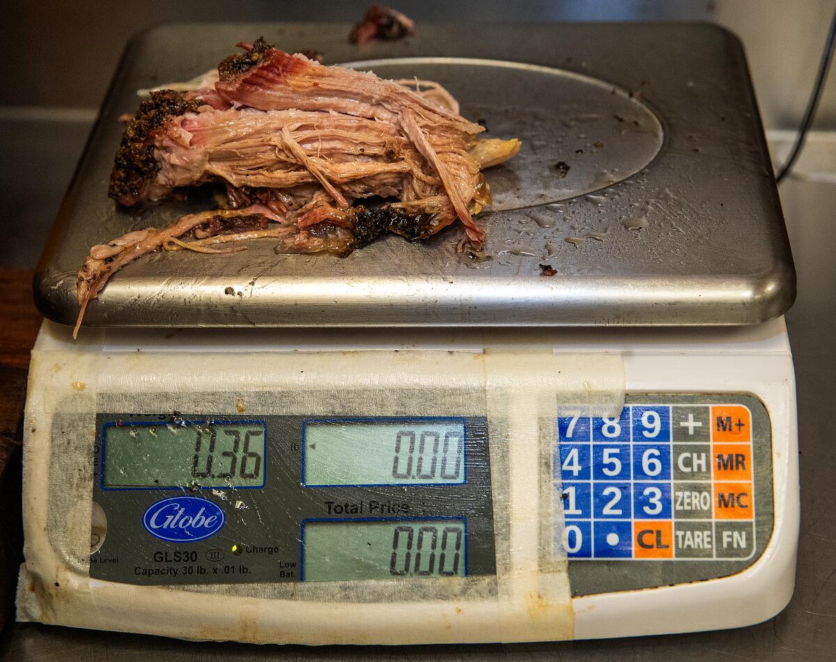Pulled pork is weighed on a kitchen scale 