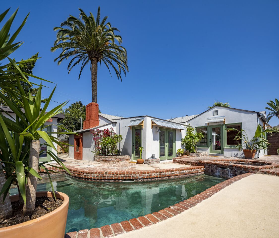 The house has a small, brick-rimmed pool.