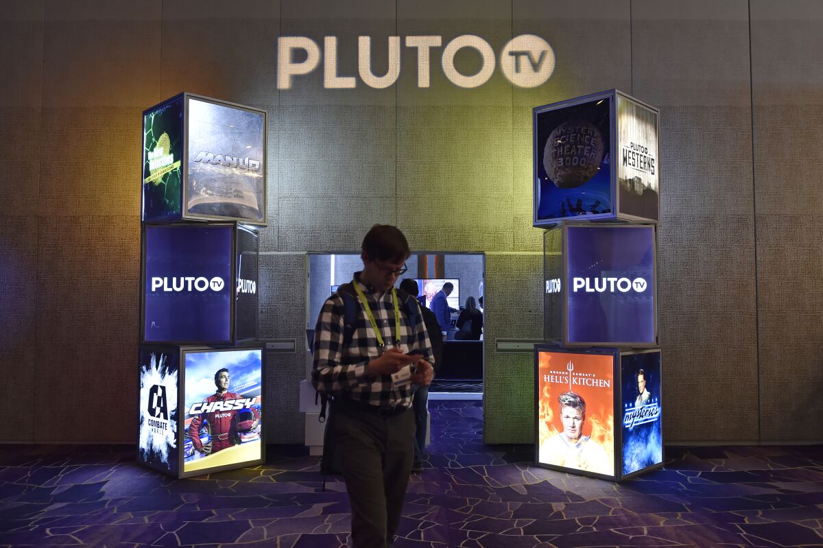 An attendee walks by the Pluto TV booth during CES 2019 at the Aria Resort & Casino in Las Vegas.