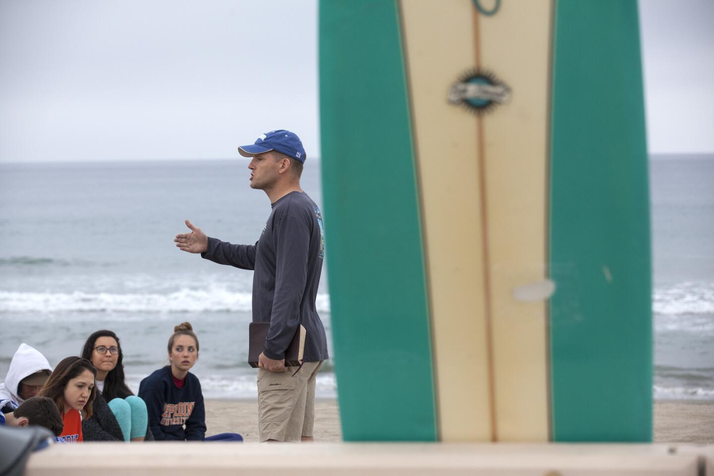 Students listen to a short morning sermon by Rob Shearer at Pepperdine's Surf Chapel on Zuma Beach. Shearer is an assistant professor at the university.