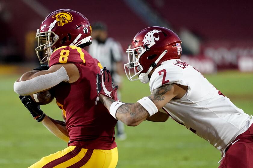 Southern California wide receiver Amon-Ra St. Brown, left, catches a touchdown pass against Washington State defensive back Derrick Langford during the first half of an NCAA college football game in Los Angeles, Sunday, Dec. 6, 2020. (AP Photo/Alex Gallardo)