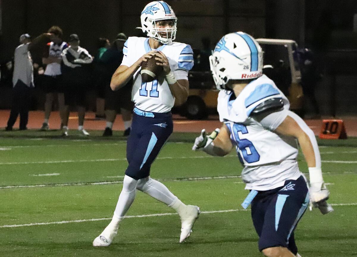 Corona del Mar quarterback Kaleb Annett (11) drops back to pass in a Sunset League game against Edison on Friday.