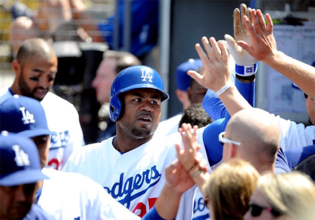 Dodgers outfielder Carl Crawford celebrates in the dugout after hitting one of his two home runs on Sunday.