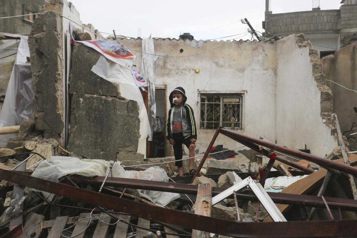 Un niño palestino está parado entre las ruinas 