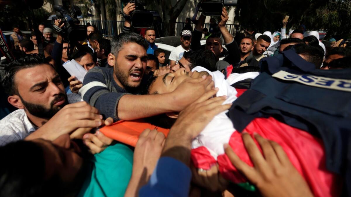 The body of Yasser Murtaja is carried by mourners during his funeral in Gaza City on April 7, 2018. Murtaja was fatally shot during protests at the Gaza-Israel border.