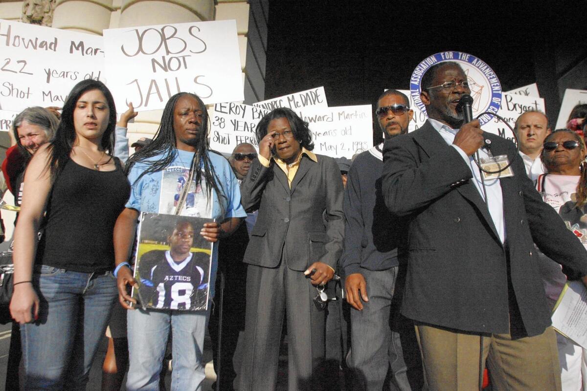 Activists and family members of Kendrec McDade rally outside Pasadena City Hall in April 2012. McDade’s mother, Anya Slaughter, holds a photo of her son, who was shot to death by police.