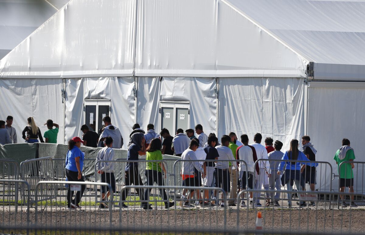 Children line up to enter a tent at the Homestead Temporary Shelter for Unaccompanied Children in Homestead, Fla. 