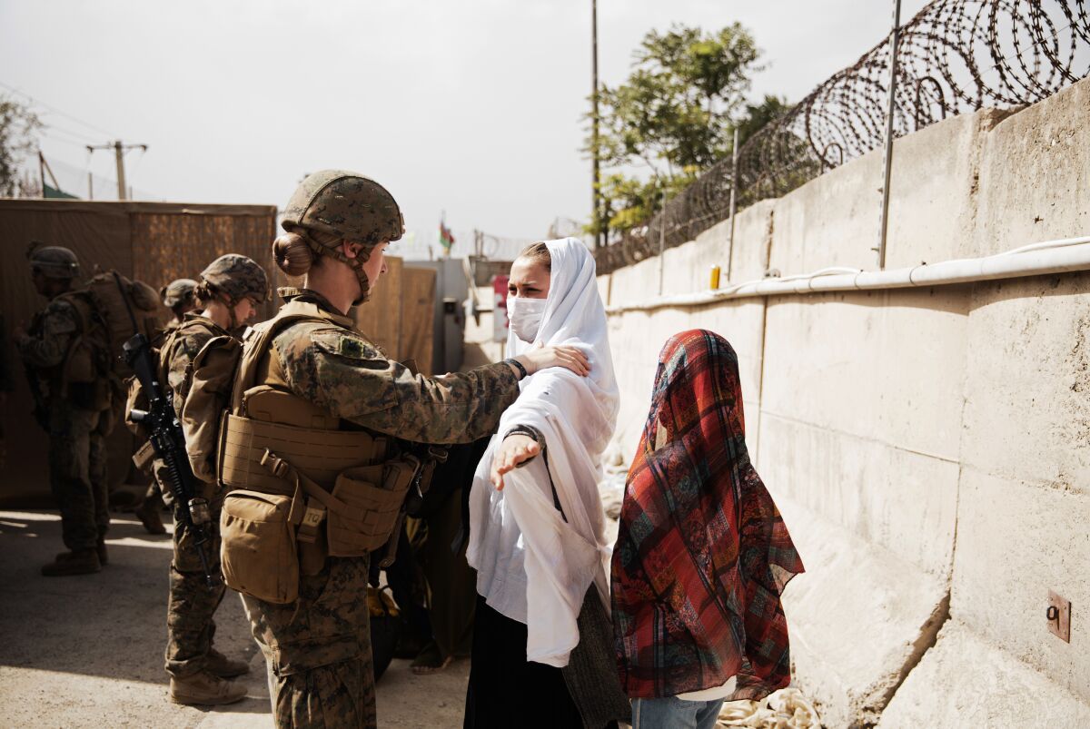 Marines process two civilians through an evacuee control checkpoint in Kabul, Afghanistan, Wednesday, Aug. 18, 2021.  