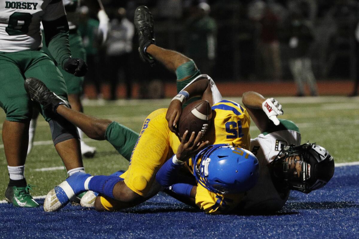 Crenshaw wide receiver Zion Bennett hangs on for a touchdown catch in front of Dorsey's Mychai Williams in the first half.