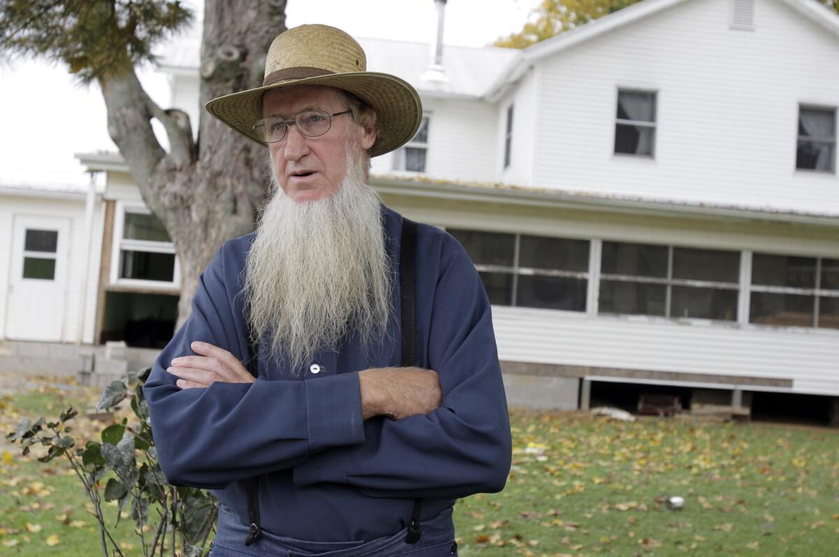 In this 2011 file photo, Sam Mullet stands in front of his Bergholz, Ohio, home. An appeals court on Wednesday overturned the hate-crime convictions of 16 Amish in beard- and hair-cutting attacks on fellow members of their faith in Ohio.