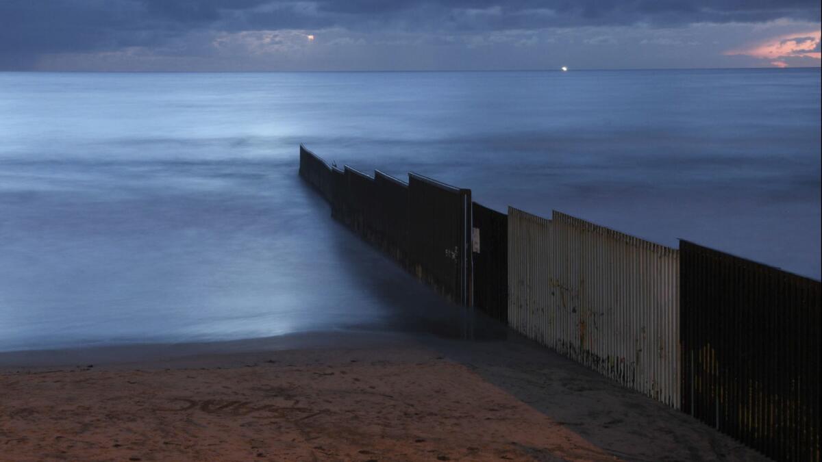 The sun sets over the U.S.-Mexico border wall that runs into the Pacific Ocean in Tijuana, Mexico on Feb. 28.