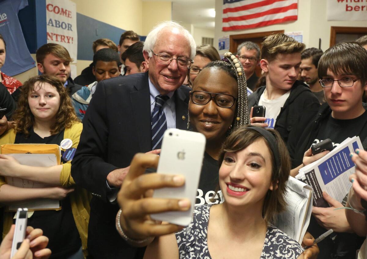 Vermont Sen. Bernie Sanders, running for U.S. president as a Democrat, poses for a selfie with supporters at his campaign office on Sunday, Dec. 13, 2015, in Waterloo, Iowa. (Bryon Houlgrave/The Register via AP)