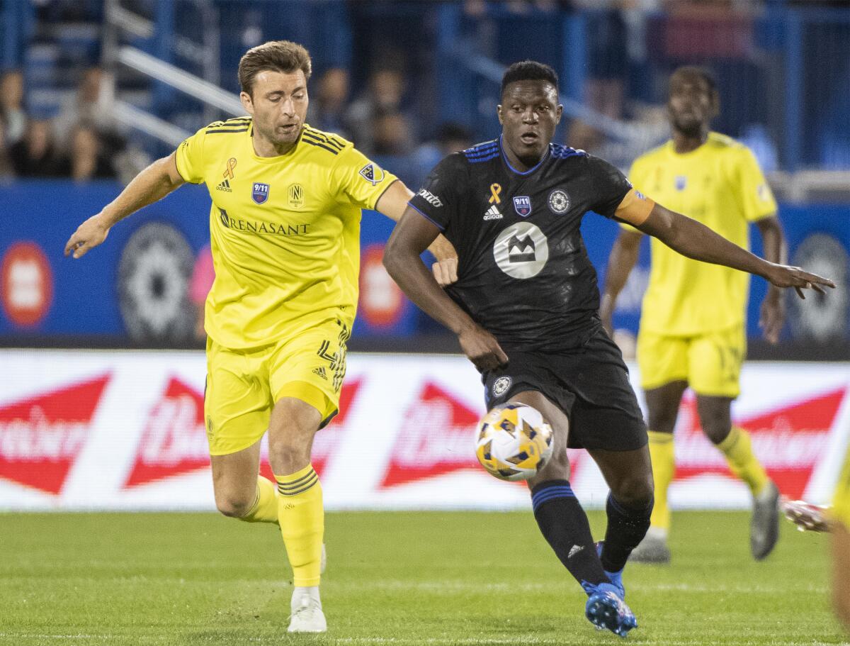 CF Montreal's Victor Wanyama, right, challenges Nashville SC's Dave Romney (4) during the first half of an MLS soccer match Saturday, Sept. 11, 2021, in Montreal. (Graham Hughes/The Canadian Press via AP)