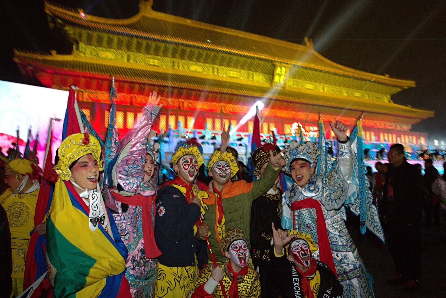 Performers pose for photographs before counting down to the new year in Beijing.
