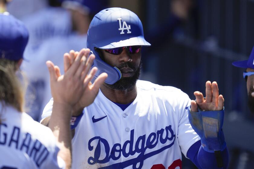 Los Angeles Dodgers' Jason Heyward (23) celebrates in the dugout after scoring off of a sacrifice fly.