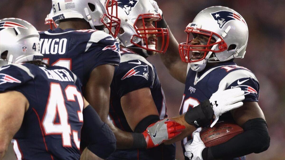 Patriots running back James White celebrates with his teammates after scoring a touchdown against the Texans during a game on Jan. 14.