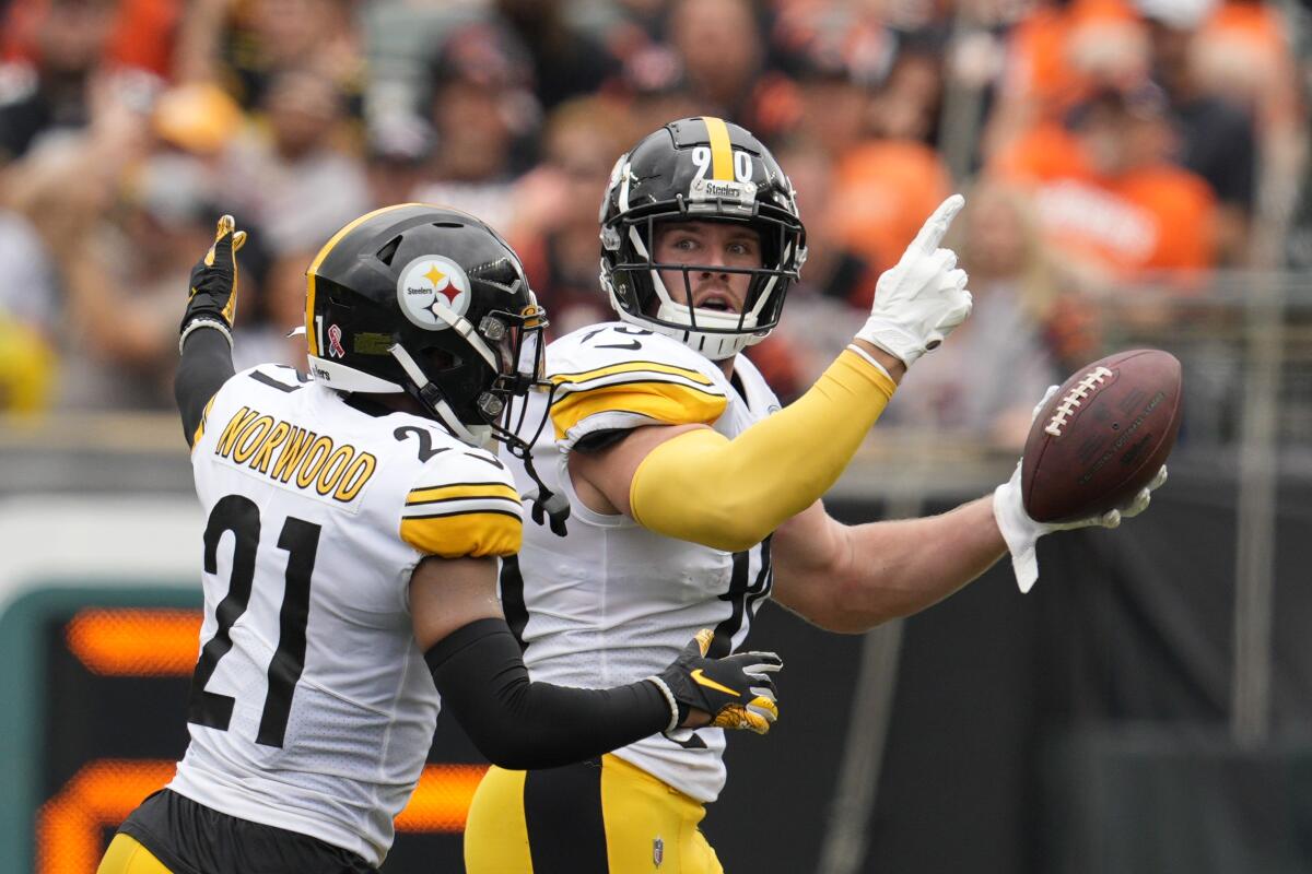 Pittsburgh Steelers linebacker T.J. Watt (90) celebrates after an interception with safety Tre Norwood (21) during the first half of an NFL football game against the Cincinnati Bengals, Sunday, Sept. 11, 2022, in Cincinnati. (AP Photo/Jeff Dean)