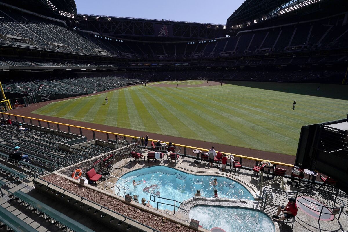 Fans swim in the pool at Chase Field as they watch the Arizona Diamondbacks play Cleveland.