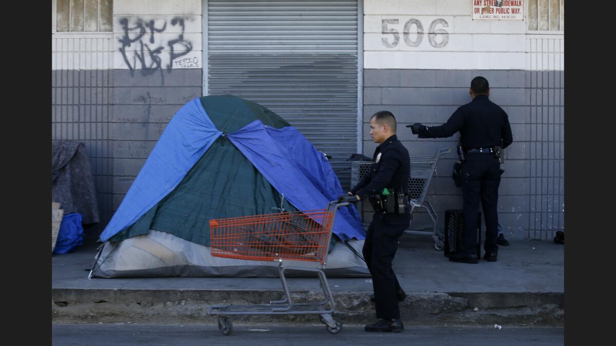 LAPD officers find several shopping carts in the homeless encampments on Stanford Avenue near 5th Street in downtown Los Angeles during a cleanup of skid row.
