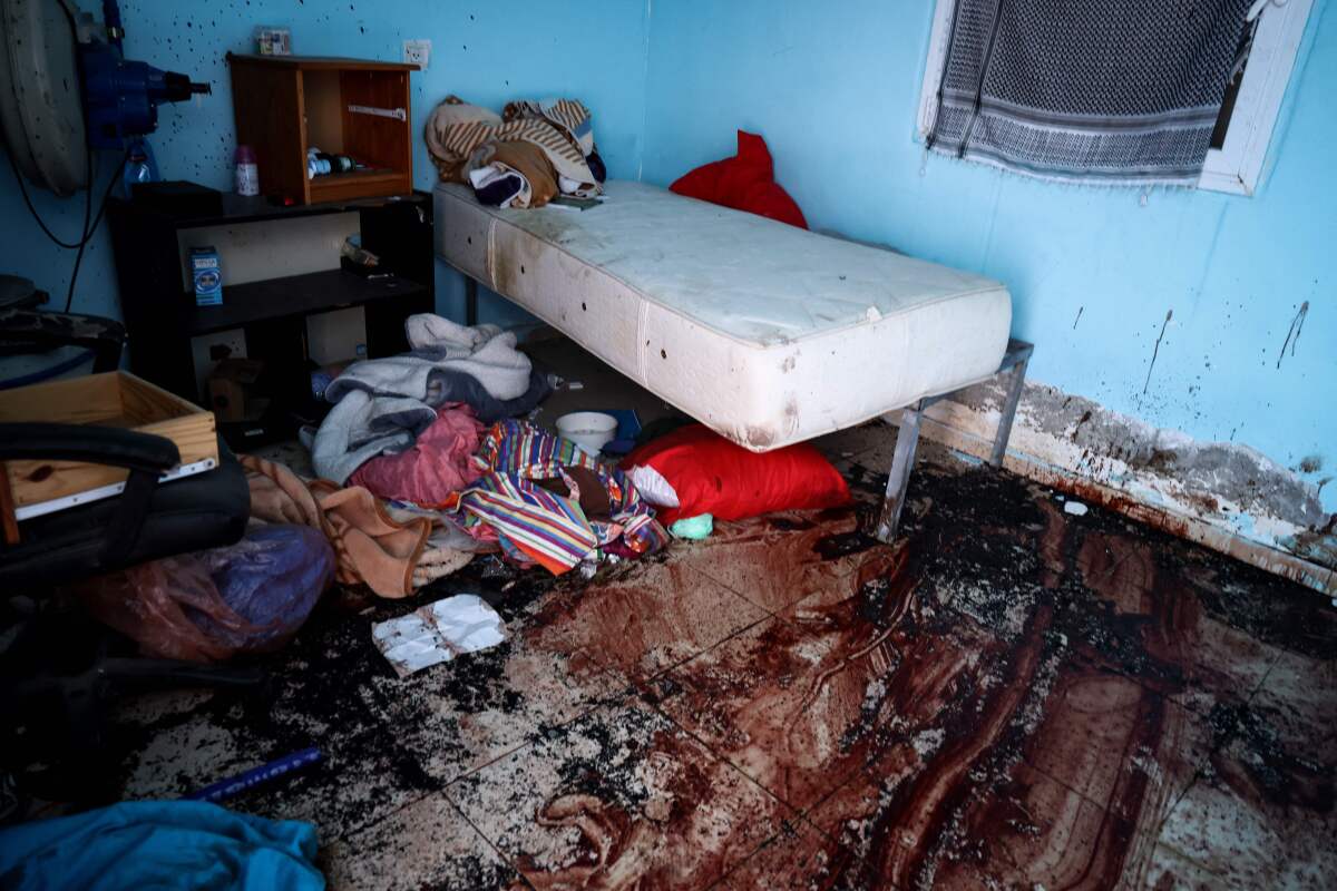 A ransacked bedroom with blood on the floor.