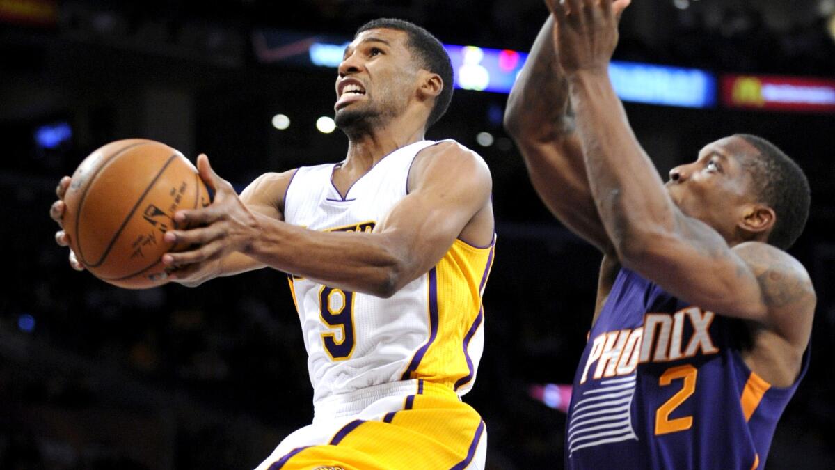 Lakers guard Ronnie Price, left, puts up a shot in front of Phoenix Suns point guard Eric Bledsoe during the first half of Sunday's game at Staples Center.