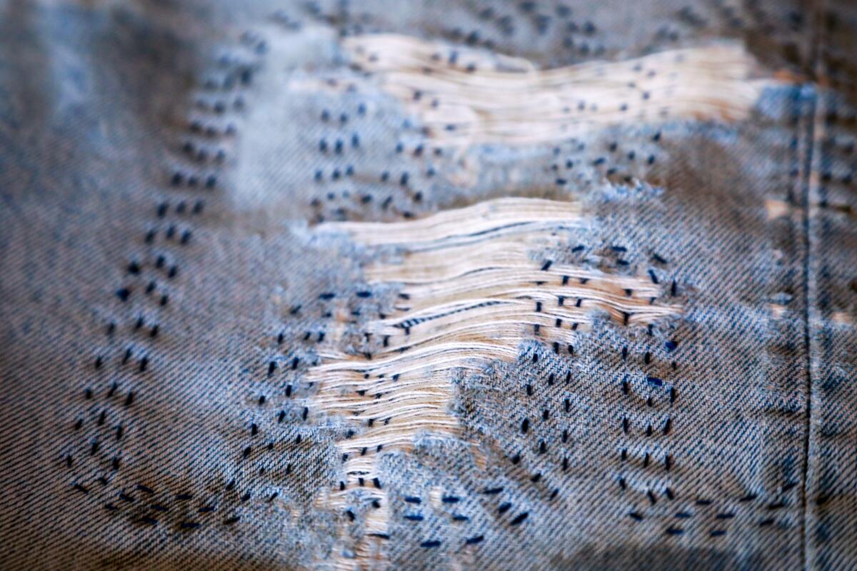 Un détail de coutures créatives sur une paire de jeans bleu denim.