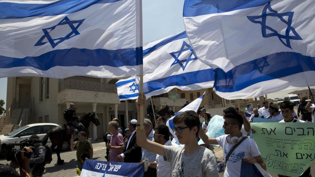 Activists carry Israeli flags in the Israeli Arab town of Umm El Fahem on Aug. 9.