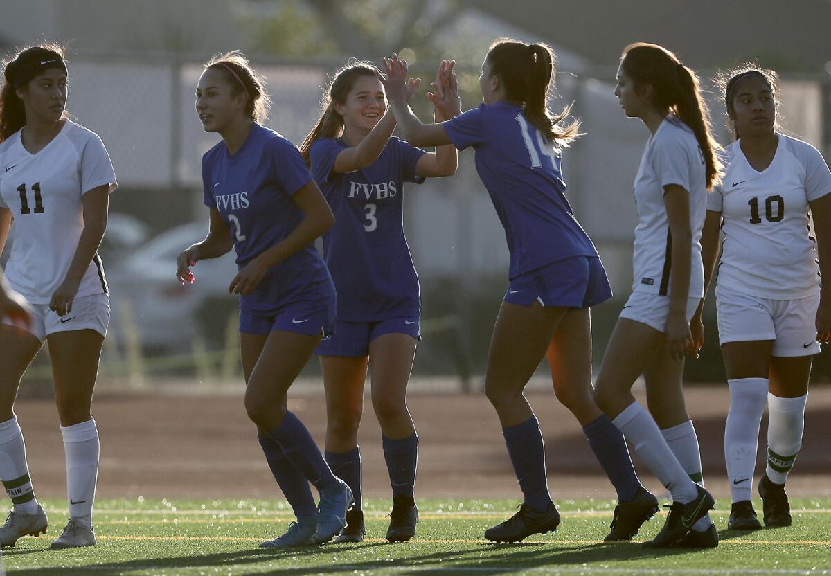 Fountain Valley's Zoe La Clair (3) receives a double high-five from Lacy Ruston after La Clair scored a goal in the 38th minute against Godinez on Thursday in a nonleague match at home.