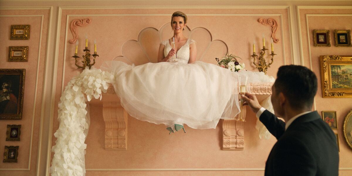 A woman in a wedding dress sits on a mantle