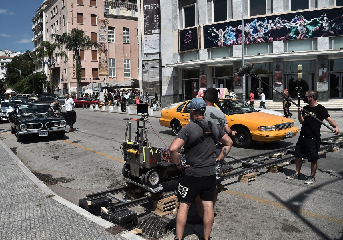 Antonio Banderas (left, background) enters a car, flanked by a crew member.