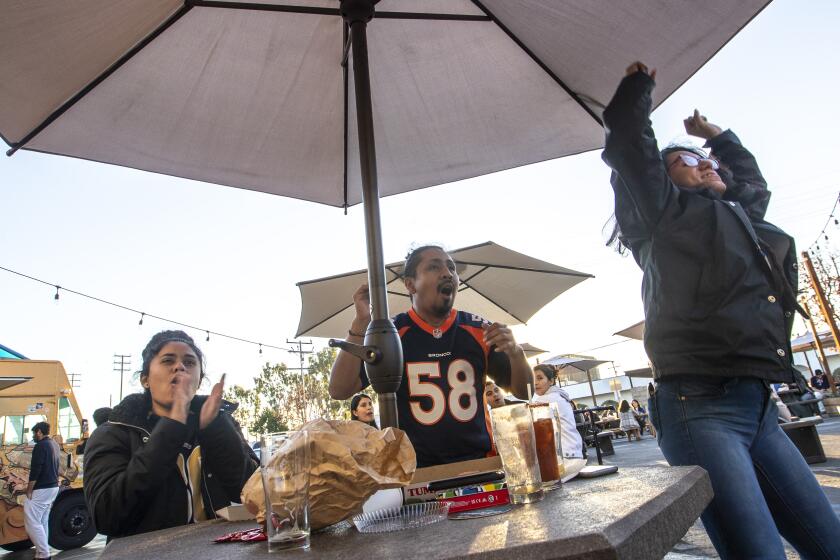 Inglewood, CA - January 30: Rams fans from right, Marilyn Monterrojas, Jesus Cisneros and Jocelyn Monerrojas react as Rams score a touchdown while watching the game at Three Weavers Brewing Sunday, Jan. 30, 2022 in Inglewood, CA. (Brian van der Brug / Los Angeles Times)
