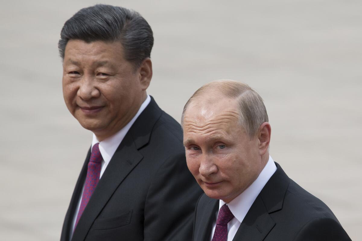 Xi Jinping and Vladimir Putin walking together. 