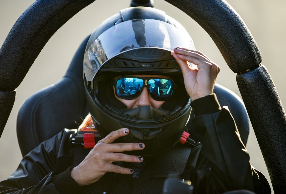 Kirin Kunkle, 17, with the Huntington Beach High electric race car team takes off his helmet following a test drive.