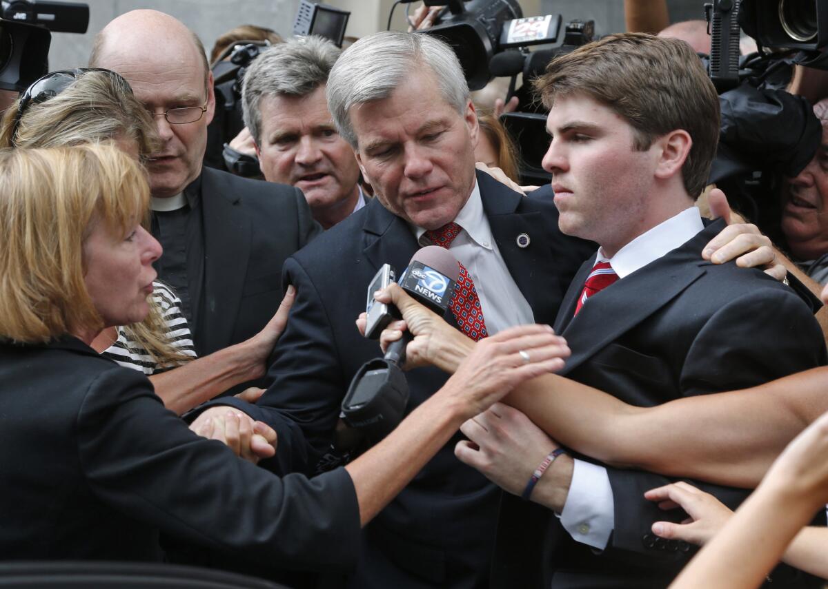 Former Virginia Gov. Bob McDonnell, center, is mobbed by media as he gets into a car with his son, Bobby, right, after he and his wife, former first lady Maureen McDonnell, were convicted on multiple counts of corruption at Federal Court in Richmond, Va.