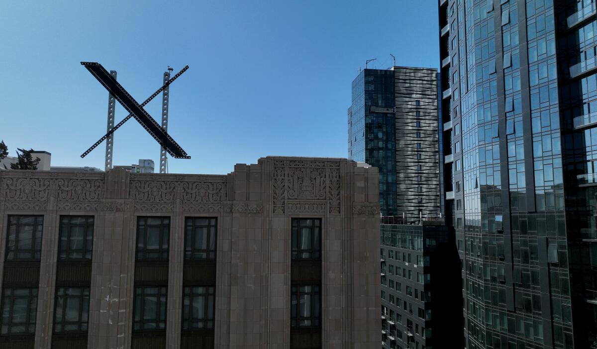A large X logo is visible on the roof of X headquarters in San Francisco.