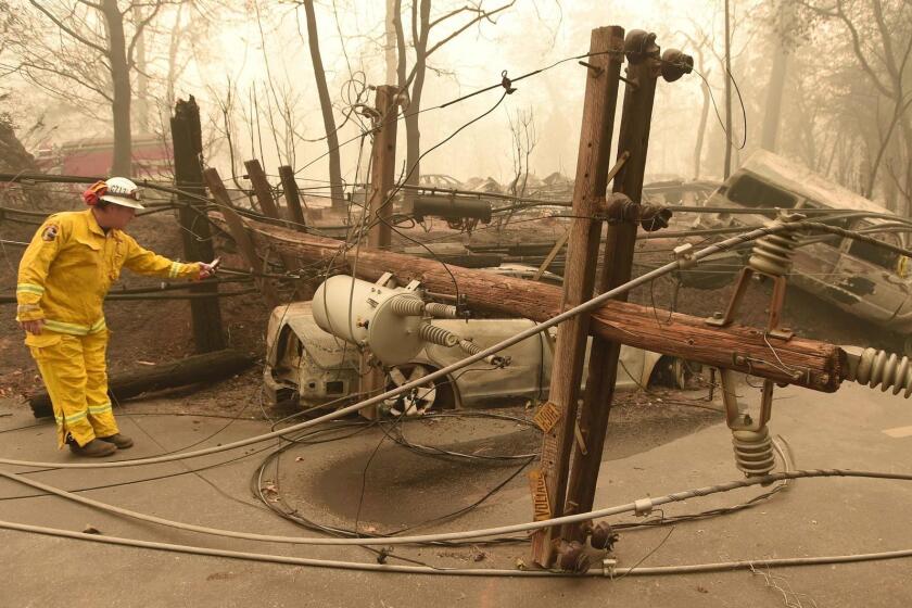 (FILES) In this file photo taken on November 10, 2018 CalFire firefighter Scott Wit surveys burnt out vehicles near a fallen power line on the side of the road after the Camp fire tore through the area in Paradise, California. - Obsolete installations, negligence, a culture of profit at the expense of safety and even "falsified" inspection reports. The complaints have been pouring in against energy supplier Pacific Gas and Electric Company (PG&E), implicated in the deadly fires in California in 2017 and 2018. (Photo by Josh Edelson / AFP)JOSH EDELSON/AFP/Getty Images ** OUTS - ELSENT, FPG, CM - OUTS * NM, PH, VA if sourced by CT, LA or MoD **