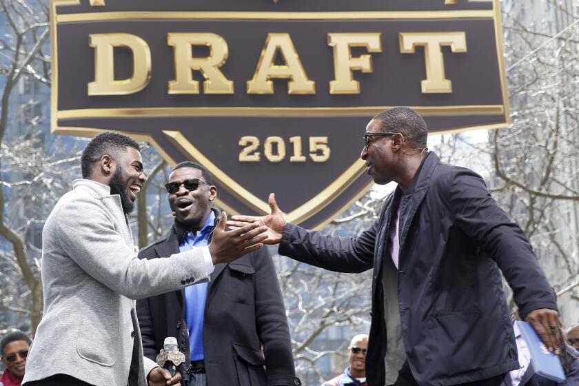 Alabama's Landon Collins, left, is greeted by Michael Irvin, center, and Cris Carter during introductions at a pre-draft event in Chicago on Wednesday. The NFL draft begins Thursday evening.