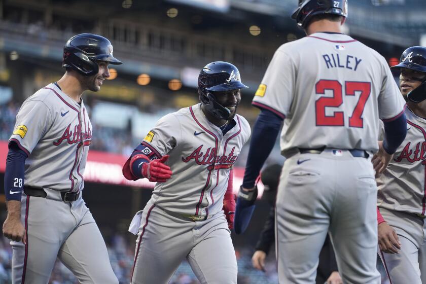 Michael Harris II (centro) festeja con sus compañeros de los Bravos de Atlanta, luego de conectar un grand slam en el juego ante los Gigantes de San Francisco, el miércoles 14 de agosto de 2024 (AP Foto/Godofredo A. Vásquez)