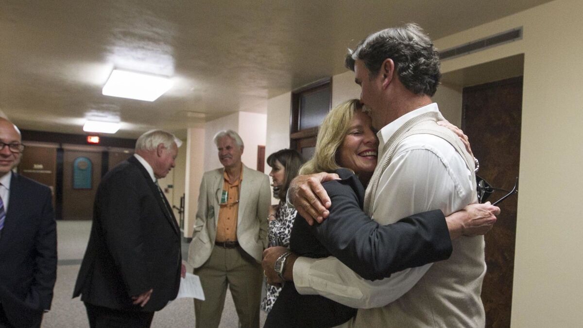 Rita Brandin, of Newland Communities, gets a hug in the hallway after the San Diego County Board of Supervisors voted 4-0 last month to approve the controversial Newland Sierra housing project in North County.