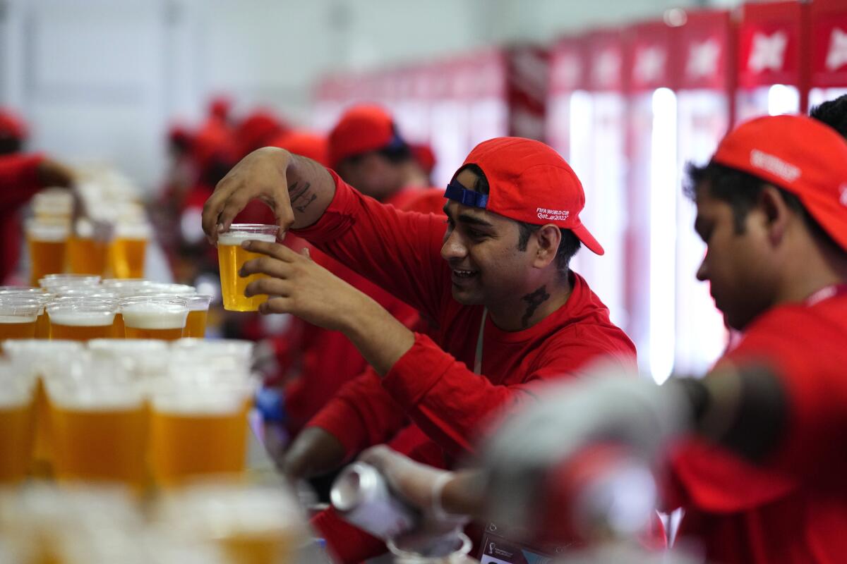 FILE - Staff member holds a beer at a fan zone ahead of the FIFA World Cup, in Doha, Qatar Saturday