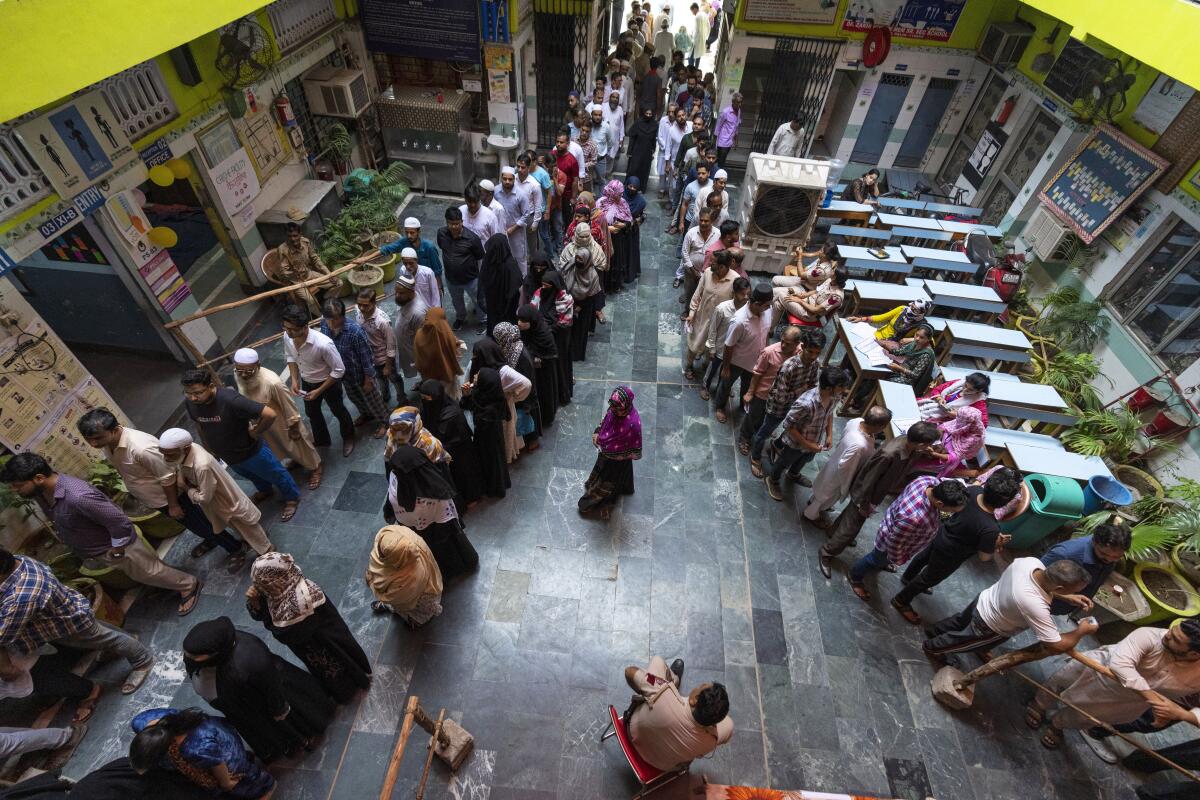 People line up inside a building to vote. 