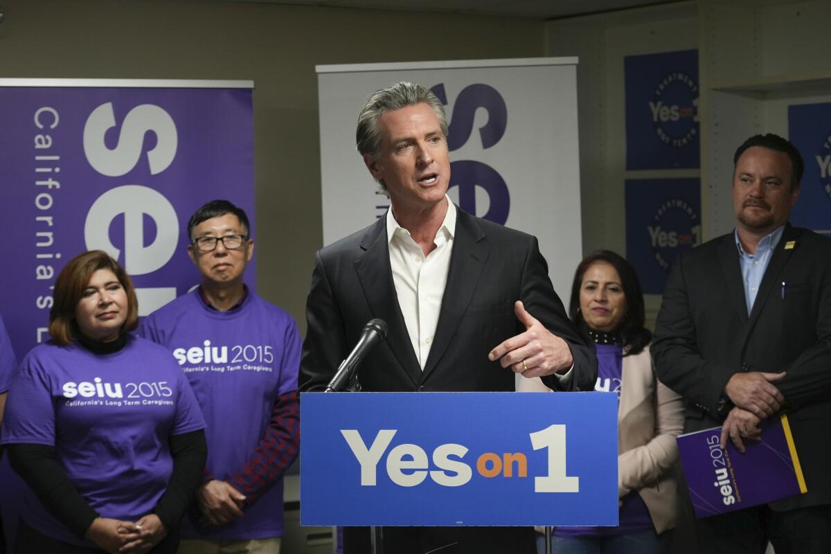California Gov. Gavin Newsom stands at a lectern reading "Yes on 1."