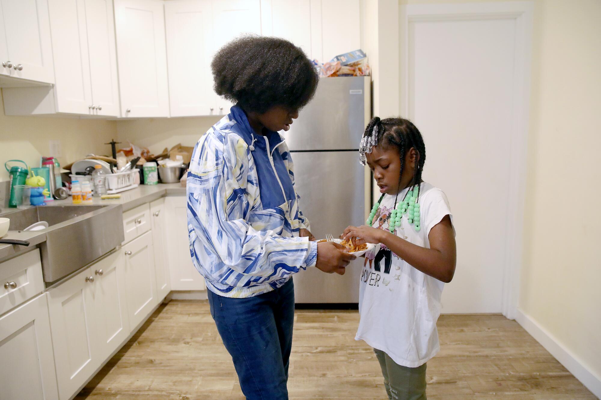 Courtney Bailey, mother of five children, serves lunch to daughter Noelle (cq) Morris, 7, at their apartment in Los Angeles