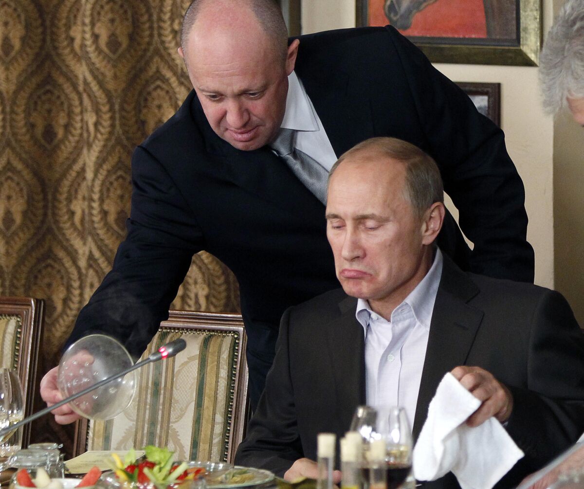 Man serves food to Vladimir Putin